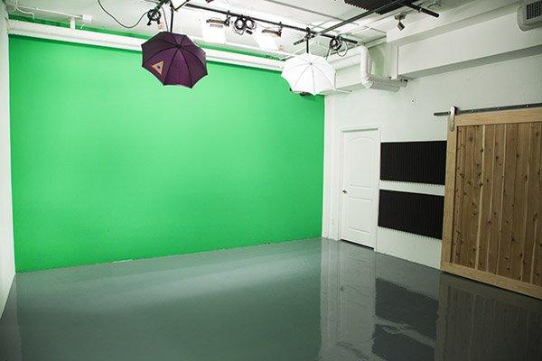 Full service studio with editing bays, overhead rack lighting, green screen