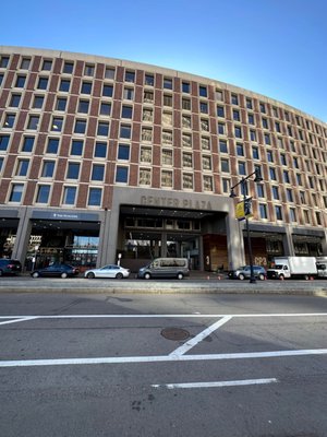 The Birthplace of The First Telephone is a Hidden Gem across from Center Plaza behind a wall, bushes & sign for JFK Building in Boston.