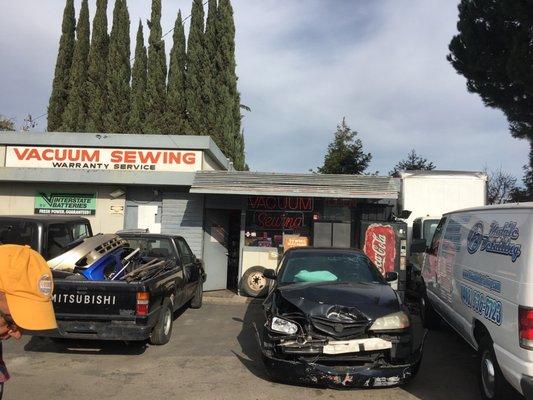 An odd ball kind of place with a bunch of junked cars and no real parking in front.