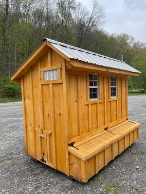 4x8 Quaker Rustic Pine Board & Batten Coop. Features with a Grey Metal Roof. Shows the bottom hinged chicken door that is also the ramp.