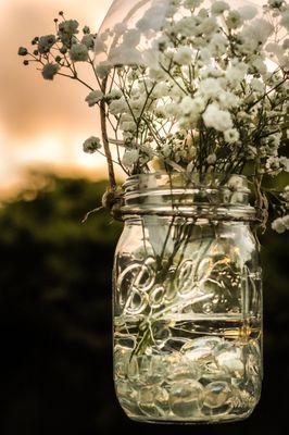 Baby's Breath with ribbon tied to the mason jars. Beautiful sunset too