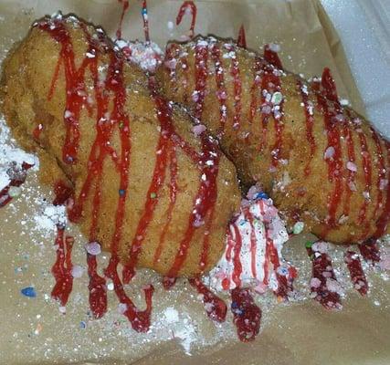 Fried Twinkies drizzled with raspberry sauce and sprinkled with Skittles dust