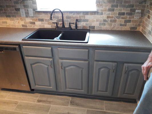 Refaced cabinets, new solid surface countertops, tile floor, stone backsplash.