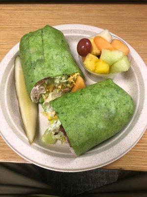 Chicken bacon club wrap with fresh fruit and a pickle