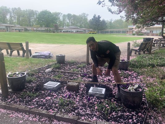 Gabe Pelaggi placing the granite stone just right.   (Hanover Park High School Purple Heart Recipient Garden)