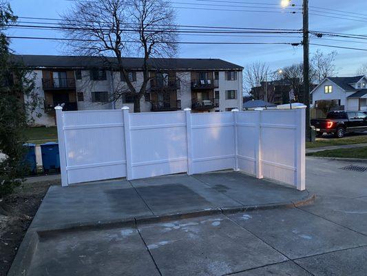 Garbage can pad & fence at apartment complex.