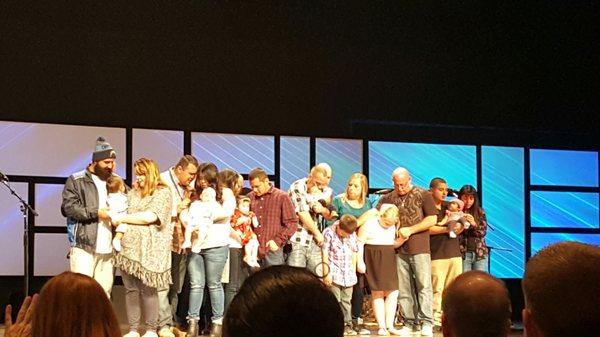 Baby Dedication. Pastor prayers over the family as they dedicate their child to God