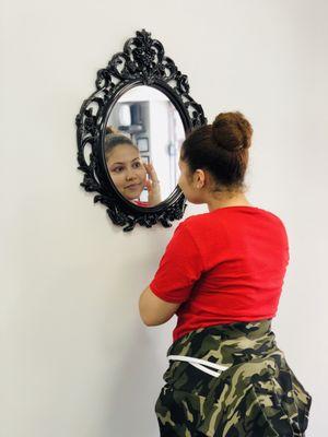 A beautiful customer admiring herself after getting her eyebrows done from your very own Indian Eyebrows