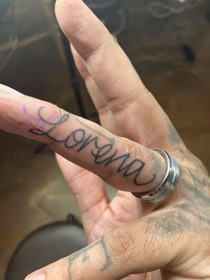 Wife's name on finger.