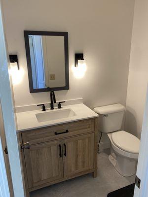 Nice upgrade. Painted walls, new vanity, mirror, lights, and flooring.