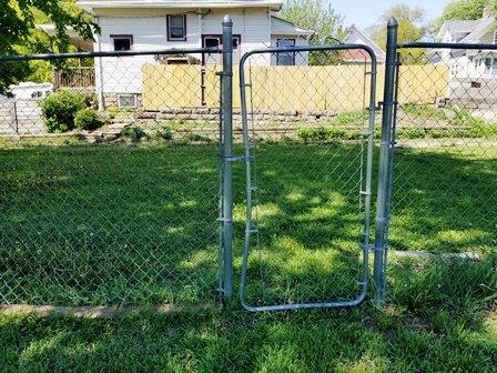 Damaged gate in chain link fence.