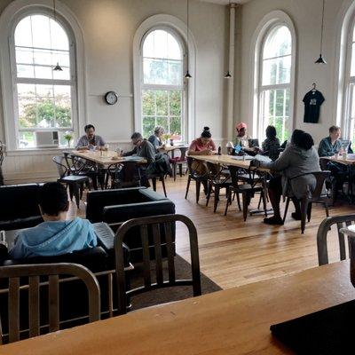 Sunlit cafe with large windows and a thriving community of writers and artists attending VCFA.