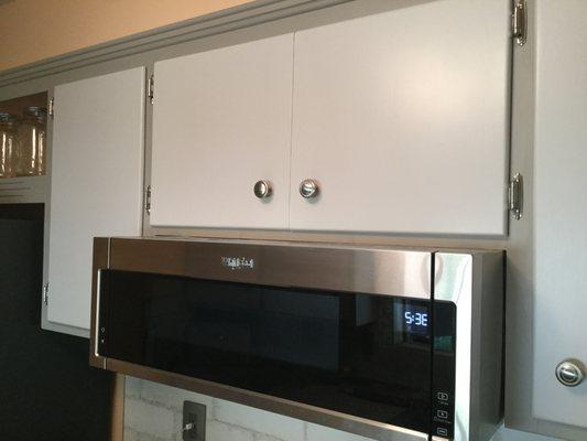 Shortened cabinet over cooktop to accommodate microwave/vent.