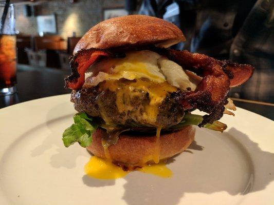 Burger. Caramelized onion, cheddar cheese, homemade pickles, lettuce, tomato, condiments, brioche bun. $7. Plus fried egg ($2), bacon ($2).