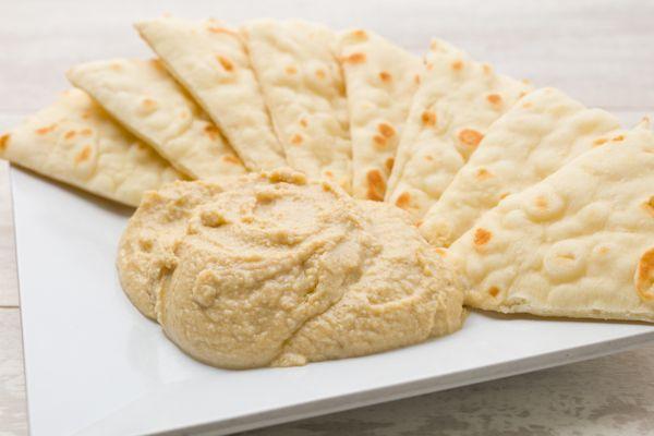 Creamy hummus served with delicious and warm pita bread.