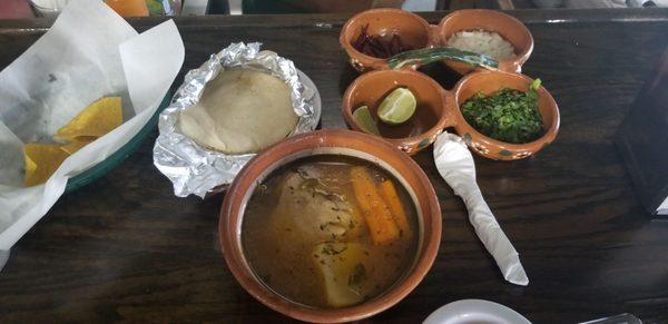 Caldo de pollo with a stack of tortillaz and condiments, just like in Mexico