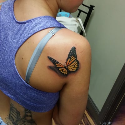 Realistic butterfly sitting on her shoulder