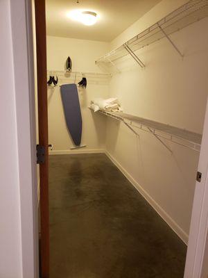 Extremely large walk in closet with ironing board and hangers