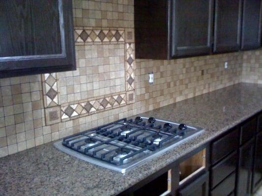 After photo of kitchen update : Re-stained/aligned kitchen cabinets, new granite counters tops as well as tile back splash