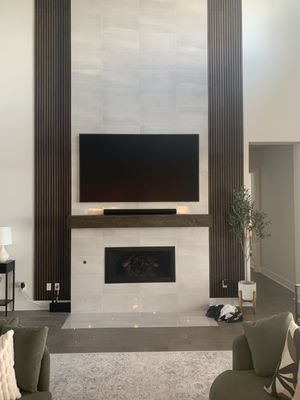 A beautiful 75 inch Samsung frame TV over a tile fireplace with in wall wiring in Bee Caves near Sweetwater community