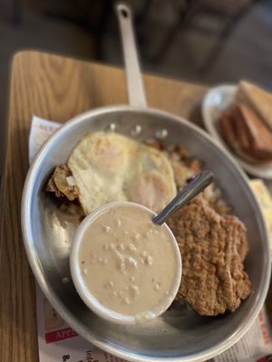 Country friend steak, eggs over medium with gravy hash browns and toast