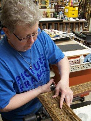 We keep your work in-house and hand build our frames on premises - as Emma is doing.