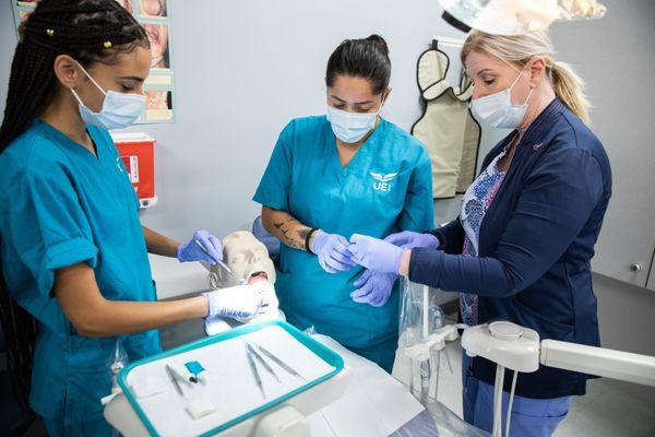 Dental Assistant students working in lab with instructor guidance.