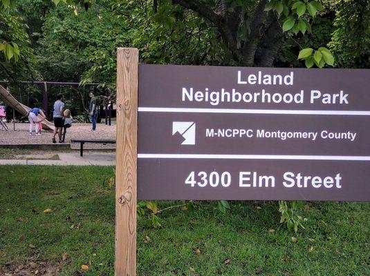 #park sign with #parkbench, #swings and tall #slide in background #lelandneighborhoodpark #chevychasemd