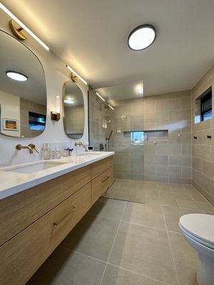 Primary bathroom with floating cabinets, curbless shower.