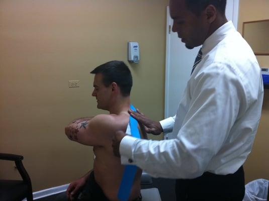 Dr. Davis applying kinesio tape to a sports injury.