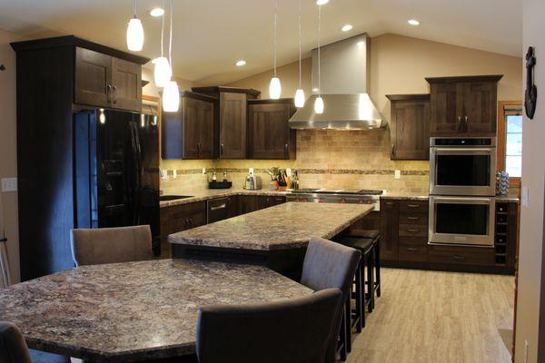 Full kitchen remodel with new hickory cabinets, new countertops, flooring, and natural stone tile backsplash.