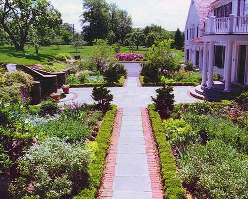 Formal entry courtyard with water feature; brick and bluestone terrace and walks; boxwood edged beds planted with perennials