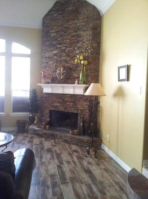 Beautiful wood look Tile floor and a stone fire place