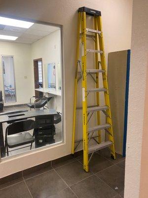 A ladder that can fall on anybody clients/students! Literally in the middle of a hallway that everyone has to walk by .