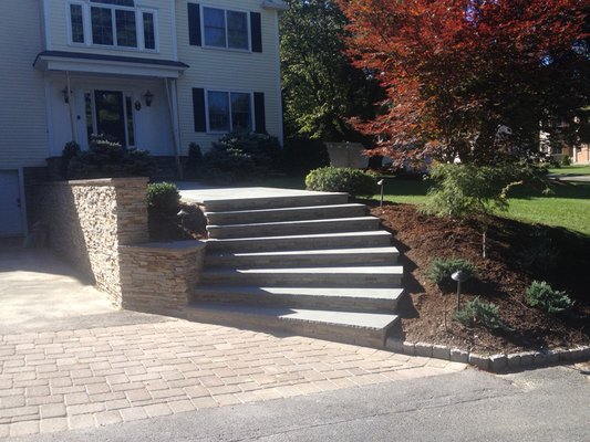 Steps with stone risers and bluestone slabs. Driveway made by pavers.