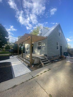 New covered porch roof, composite wrap around steps, paver sidewalk and patio, planter, exterior lighting and deck riser lighting