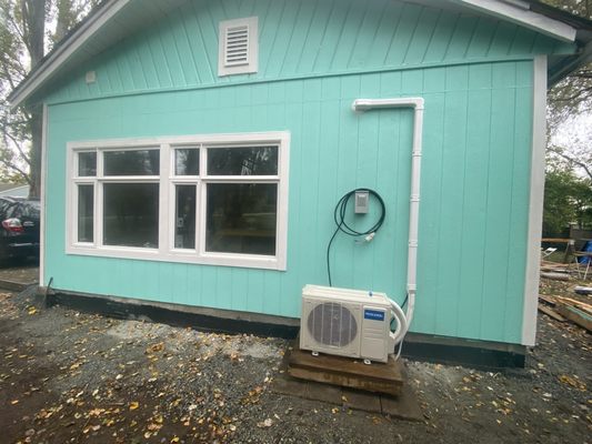 The side of the former carport framed in, included the two new windows and mini split I installled