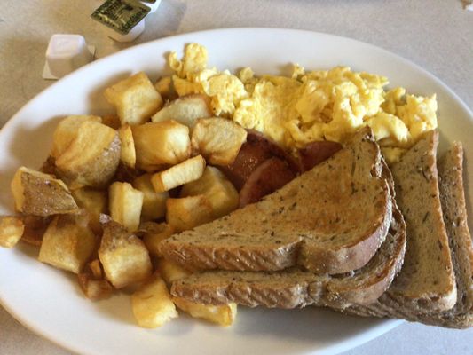 Scrambled eggs, pork roll, fried potatoes and toast