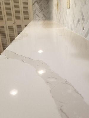 This beautiful kitchen counter is called 'Clacatta Fantasy.'  It's a quartz counter.