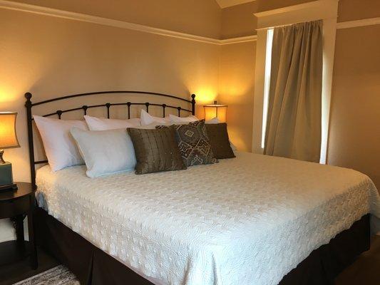 The Master bedroom of our two bedroom suite has a plush king sized bed that has a view of the East hills of Ashland.