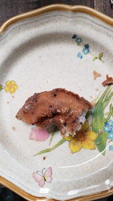 Dry, hard, unglazed bottom of a blueberry donut