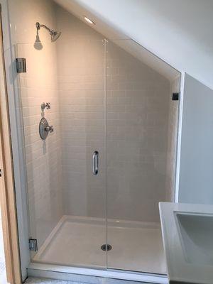 Frameless shower in attic bath with angled ceiling