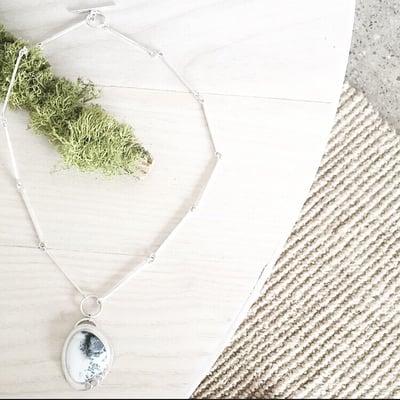 Handcrafted silver necklace with a dendritic opal at Pixel + Torch