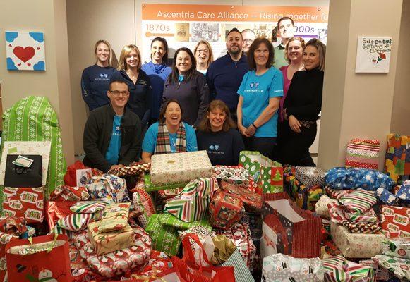 Blue Cross Blue Shield volunteers wrap Christmas presents going to clients of Ascentria's programs and services.