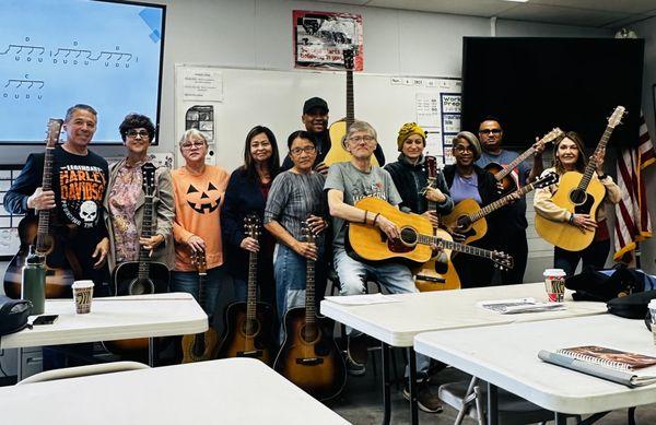 Guitar Class Students Posing with their guitars and the teacher.