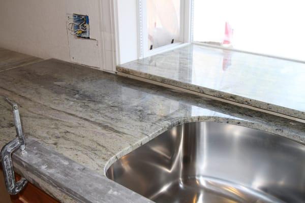 Granite counter being slipped into place.