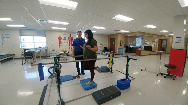 Physical therapist assistant performing exercises with patient.