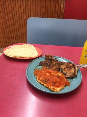 Delicious Huevos rancheros breakfast with 2 grilled chuletas and homemade tortillas. What else can I ask for. Breakfast for a king.