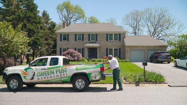 Green Pest Management truck in front of customers house.