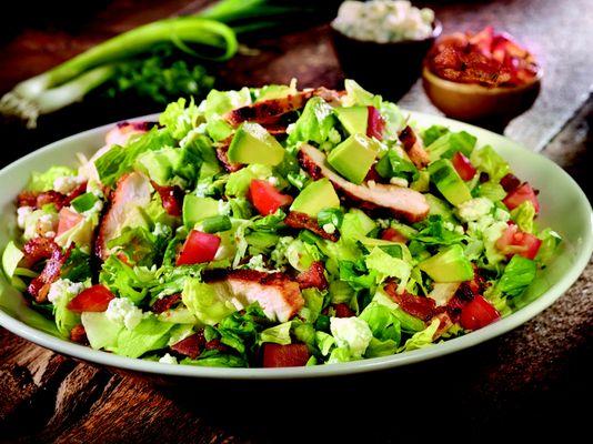 OC Chopped Salad...Applewood-spiced chicken, peppered bacon, bleu cheese, tomatoes and fresh green onions, topped with avocado & tomato.